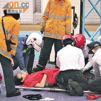  少年打籃球入樽墮地受傷，救護員即場為他包紮。	（李少雄攝）