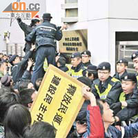 「女長毛」帶同空櫈抗議中央囚禁劉曉波，被多名警察包圍。	（黃仲民攝）