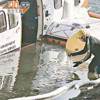 消防處蛙人協助在直升機旁邊抽取水質樣本檢驗。