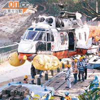 工程人員協助將直升機卸落貨車運走。