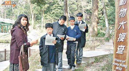鍾健琴老師（左）利用教材套在郊野公園進行科學科活動教學。	（何耀其攝）