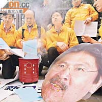 示威者在政府總部外焚燒預算案，更警告曾俊華若不修訂預算，應要問責下台。