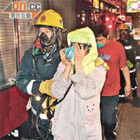 戴着被救者呼吸器的女戶主和戴着口罩的男戶主，逃離火場。