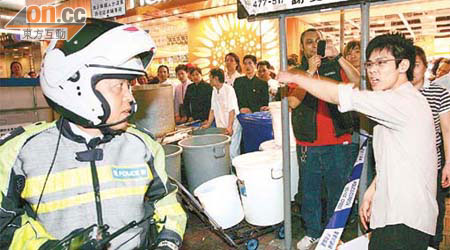 輪水場面混亂，有男子不滿水務署人員只吊下一個水缸，向警員投訴。