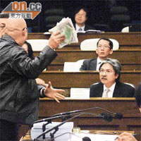 議員在議會廳內向曾俊華擲陰司紙抗議。