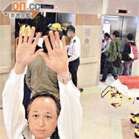 有醫院職員在鏡頭前高舉雙手，阻撓記者拍攝。