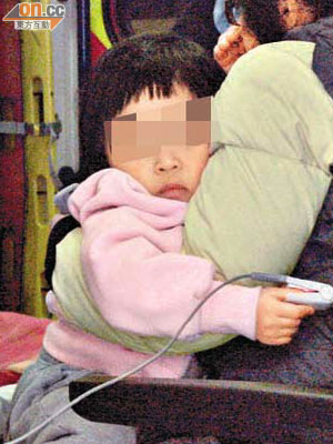 女童由母親抱着送院。	（蕭添榮攝）