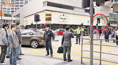 警員為曾蔭權的座駕開路，即使馬路的行人交通燈轉了綠燈（紅圈示），亦不許途人行過。	（溫國佳攝）