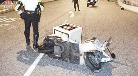 警員在電單車撞欄現場調查。	（陳錦揮攝）