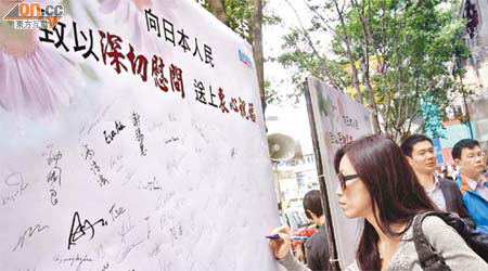 有政黨在中環街頭放告示板，讓市民簽名向日本人民致深切慰問。	（麥潤田攝）