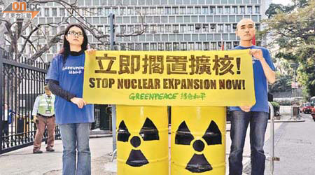 兩名綠色和平成員到政府總部抗議，反對政府擴建核電廠。