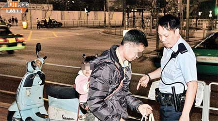 孭着女兒駕電單車的男子協助警員調查。	（文健雄攝）