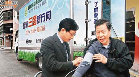 香港醫院藥劑師學會推出藥物教育講座展覽車，蘇曜華示範為李國垣量血壓。	（翁志偉攝）
