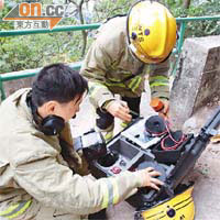 消防員用生命探測器搜索是否有人被山泥活埋。