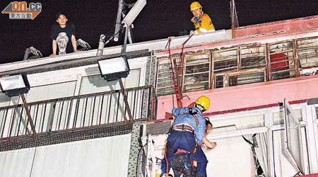企圖跳樓少女由消防「飛將軍」救回，在天台的男友（左）神情緊張。	（蕭植梧攝）