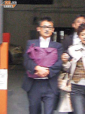 被告李文瀚（左）昨獲准保釋後，由眾親友陪同離開法庭。
