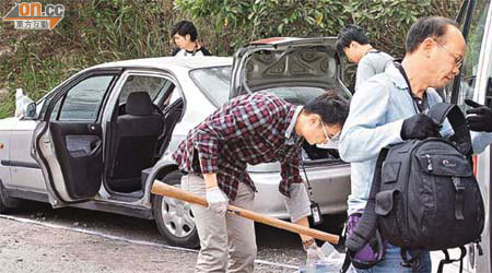 探員檢查兇徒的私家車及檢走木棍。	（林明強攝）