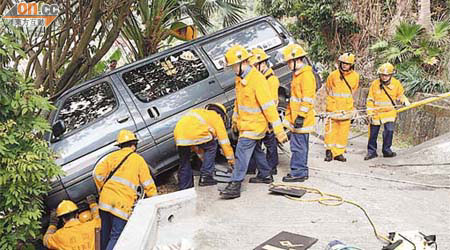 消防員設法將客貨車拖返路面。（曾紹良攝）