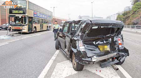 私家車與巴士相撞後停在路中，車尾嚴重凹陷撞毀。	（梁國雄攝）