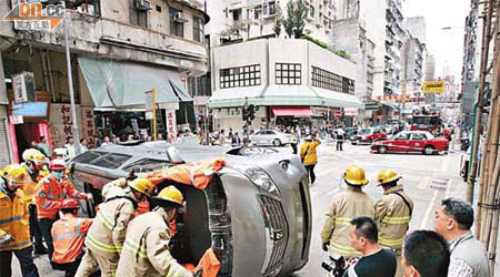七人車與的士相撞後翻側，消防員拯救被困七人車司機。	（林少兒攝）