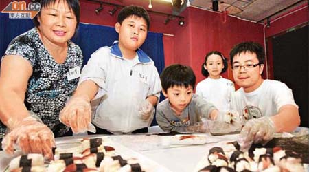 植太（左一）與兒子（左二）、林先生（右一）與一對子女合作做壽司，作為親子活動，暫時拋開高通脹的煩惱。（伍鎮業攝）