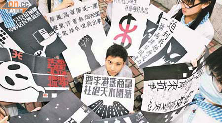 受影響中學的學生自製標語，抗議港鐵興建屏風樓，令學校變成「樓宇三文治」。