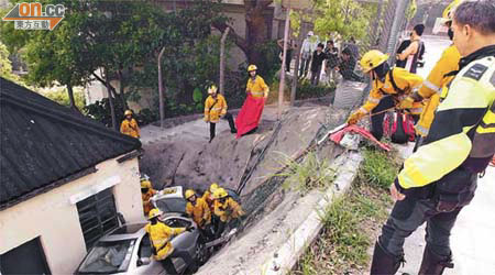 消防員游繩落山坡，拯救被困司機及乘客。	（許錦雄攝）
