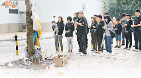 蔣世豪的妻子（左一）及親友在墮樓現場拜祭。	（李子強攝）