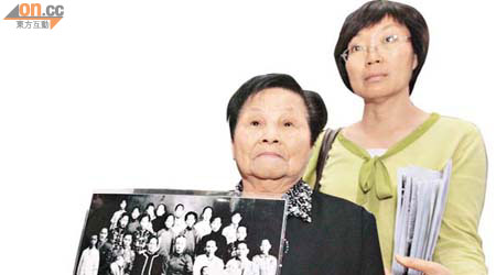郭玉蘭婆婆展示四歲時拍攝的家族大合照，她是最下排右二者。	（蘇文傑攝）
