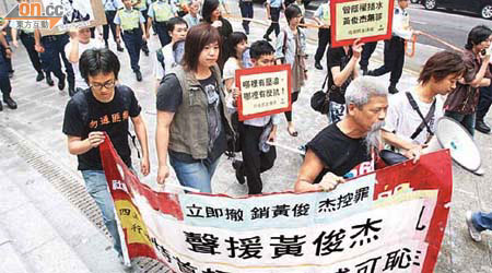 示威者一行十五人由滙豐銀行遊行至禮賓府。	（伍鎮業攝）
