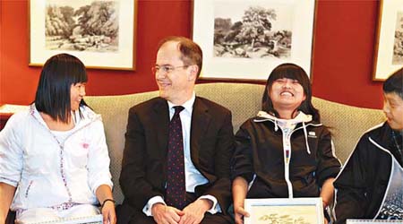 英國駐華大使吳思田，在大使館接受雲南省三位孤兒送給威廉的禮物。	（中新社圖片）