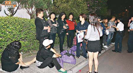 溫州團團友不滿旅行社安排入住荃灣一間酒店，一度坐街罷住抗議。	（張曉楠攝）