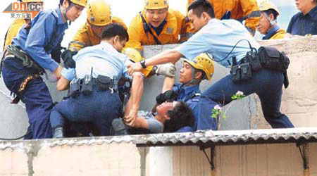 消防「飛將軍」與警員合力將危坐天台的女東主救回。	（梁卓明攝）