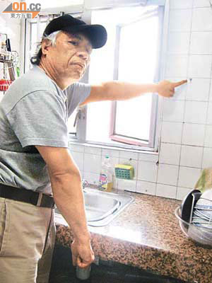 陳先生指廚房窗邊滲漏，已令廚櫃底「水浸」。