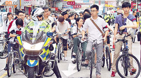 近百青年踩單車紀念六四，沿途有警察開路。		（高嘉業攝）