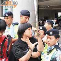高舉「通緝王光亞」示威字牌的示威人士，一度與警方就示威區範圍爭論。	（陳德賢攝）