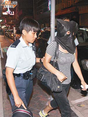 涉嫌虐兒婦人由警員蒙頭帶署助查。	（林振華攝）