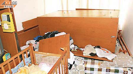 巨型吊櫃整個倒下睡床上，床邊嬰兒床圍欄亦被撞毀。	（吳欽旺攝）