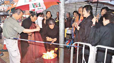 佛教團體在奪命火警現場超度亡魂，黎家大舅（左）在旁致祭。	（陳桂建攝）