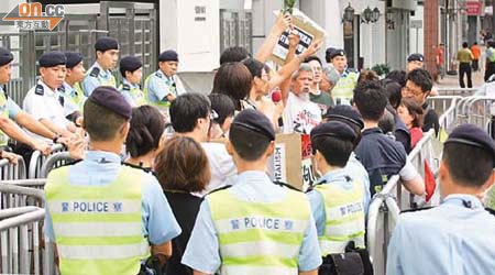 示威者將茉莉花束及標語等擲入中聯辦範圍。 （陸智豪攝）