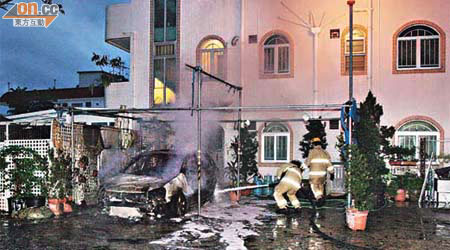 被縱火私家車嚴重焚毀，消防員射水灌救。	（蕭植梧攝）