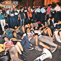 示威者躺在路上互相扣臂成為人鏈，抗衡警方的清場行動。	（羅錦鴻攝）