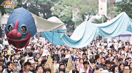藝術公民手持「兩頭蛇」遊行，諷刺政府施政「兩頭唔到岸」。	（霍振鋒攝）