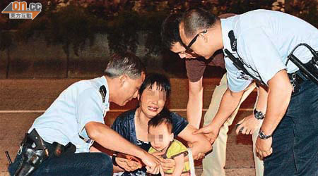 攜子女尋死婦人抱着兒子坐在馬路中央哭哭啼啼。	（沈厚錚攝）