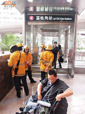 被困輪椅漢由消防員抬回路面。	（梁國雄攝）