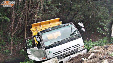 泥頭車溜後墮落水坑損毀。	（文健雄攝）