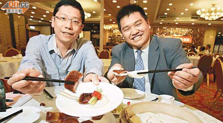 黃傑龍（左）一口氣食十二件廣式片皮鴨，酒樓太子爺陳嘉華都寫個服字。	（馮溢華攝）