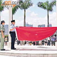 一名女教官督導兩名警員收回穿窿國旗。