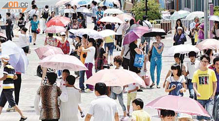 天氣炎熱，不少市民撐起雨傘防曬。	（袁志豪攝）