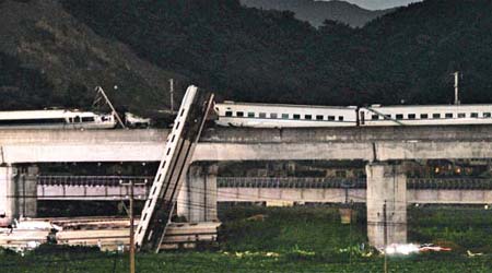 列車脫軌後部份車卡衝下高架橋。	（互聯網）